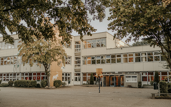 Hier ist ein  Foto der Schule mit dem Eingangsbereich zu sehen.
