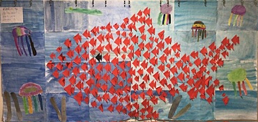 gebastelte rote Fische auf blauem Hintergrund