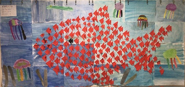gebastelte rote Fische auf blauem Hintergrund