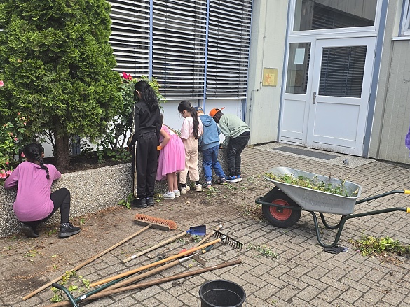 Kinder bepflanzen die Blument&ouml;pfe vor der Schule