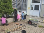 Kinder bepflanzen die Blumentöpfe vor der Schule